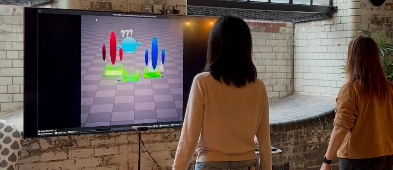 Two participants face the Social XR prototype together in a shared physical room.